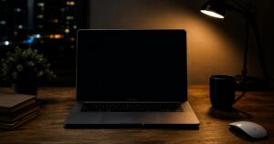 Portatile su una scrivania in legno illuminata da una lampada di notte