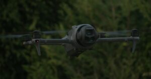 Drone DJI di ultima generazione in volo davanti a una fila di alberi