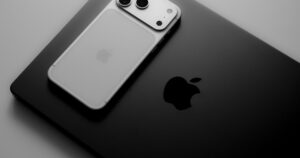 iPhone 17 Pro argento appoggiato su un MacBook scuro, in bianco e nero