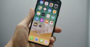 Mano che tiene un iPhone con la schermata Home