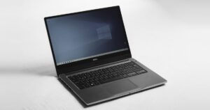 Portatile Dell aperto con il desktop di Windows su un piano bianco