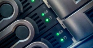 Primo piano dei cassetti dei dischi di un NAS con i LED di attività verdi accesi