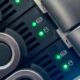 Primo piano dei cassetti dei dischi di un NAS con i LED di attività verdi accesi