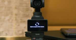 Fotocamera tascabile DJI Osmo Pocket con lo schermo ruotato che mostra un aggiornamento in corso