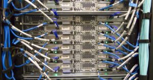 Server montati in rack con numerosi cavi di rete blu e bianchi collegati sul retro
