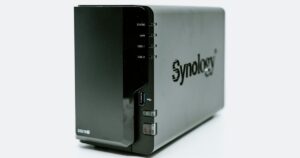NAS Synology a due bay di colore nero visto di tre quarti su sfondo chiaro, con i LED di stato e la porta USB sul frontale