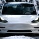 Tesla Model 3 bianca su una strada di montagna innevata