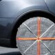 Ruota posteriore di una Tesla Model Y Juniper grigia con una calza da neve in tessuto montata sul pneumatico