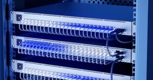 Switch UniFi in un armadio rack visti di lato, con cavi di rete bianchi collegati e luce blu