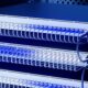 Switch UniFi in un armadio rack visti di lato, con cavi di rete bianchi collegati e luce blu
