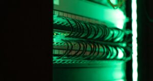 Rack di rete con cavi patch illuminati di verde in un datacenter